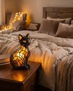 Cat-shaped night lamp glowing on a bedside table, lifestyle
